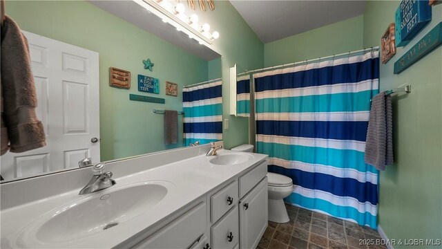 bathroom with walk in shower, vanity, and toilet