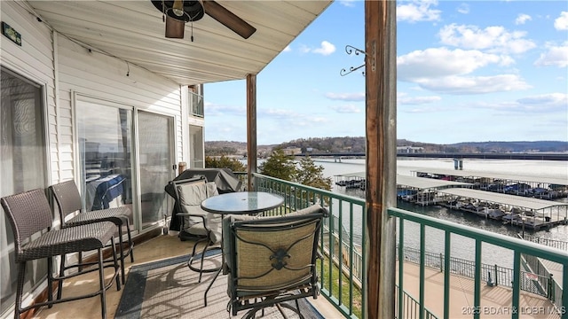 balcony with a water view and ceiling fan