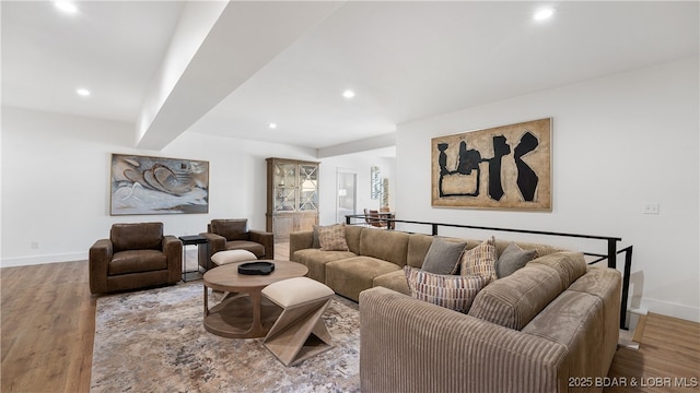 living room featuring beam ceiling and light hardwood / wood-style flooring