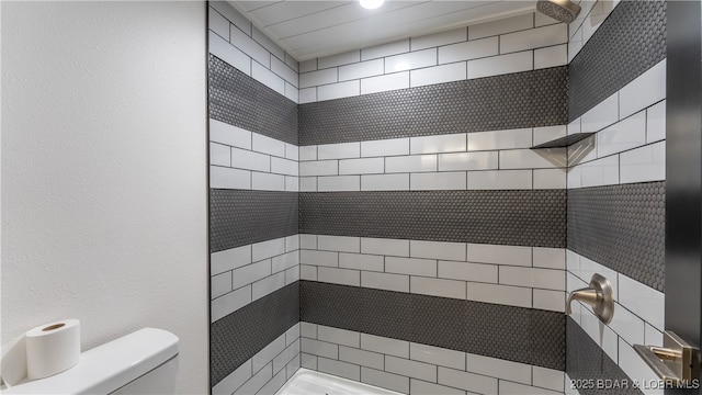 bathroom with tiled shower and toilet