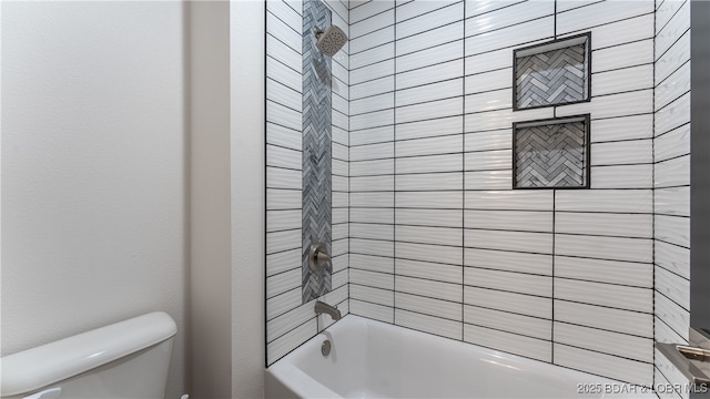 bathroom with tiled shower / bath combo and toilet