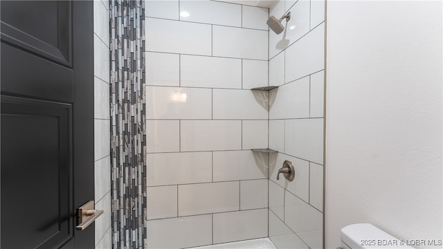 bathroom with toilet and a tile shower