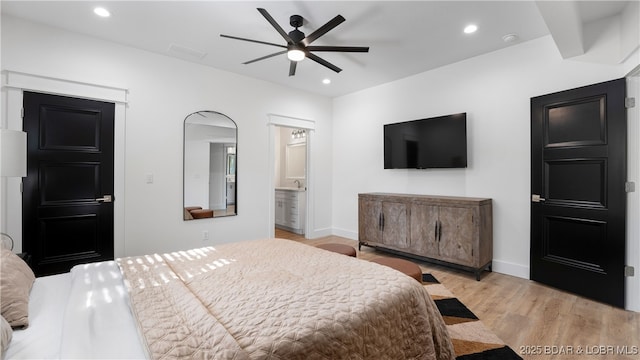 bedroom with ceiling fan, ensuite bathroom, and light wood-type flooring