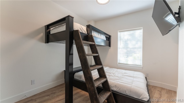 bedroom with hardwood / wood-style flooring and multiple windows