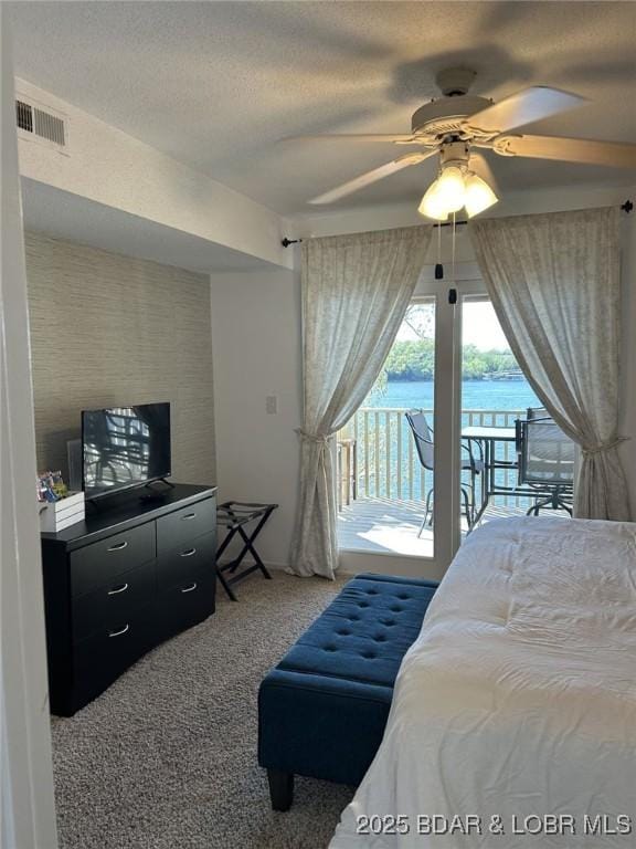 bedroom featuring a water view, ceiling fan, access to exterior, and carpet floors