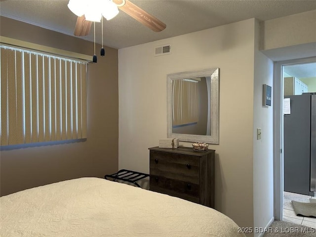 carpeted bedroom with a textured ceiling and ceiling fan