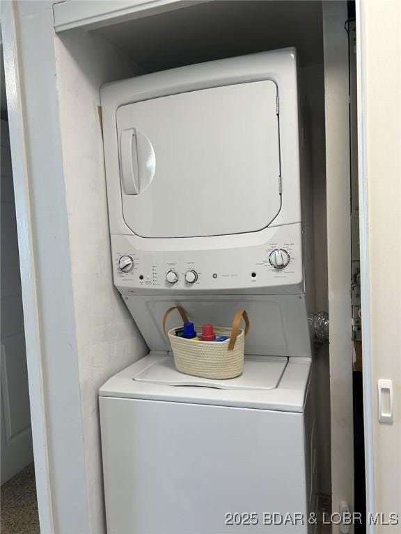 clothes washing area featuring stacked washer / dryer