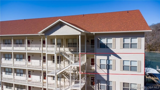 view of front of property featuring roof with shingles and stairs