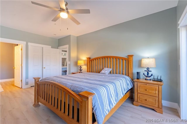 bedroom with a ceiling fan, light wood-type flooring, a closet, and baseboards