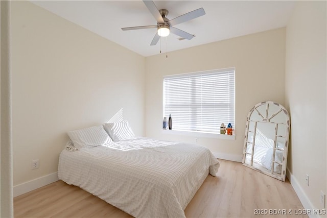 bedroom featuring wood finished floors, a ceiling fan, and baseboards