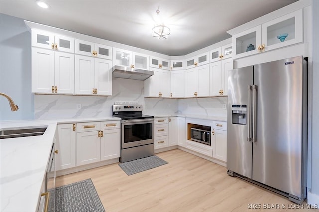 kitchen with white cabinetry, sink, light stone countertops, and appliances with stainless steel finishes