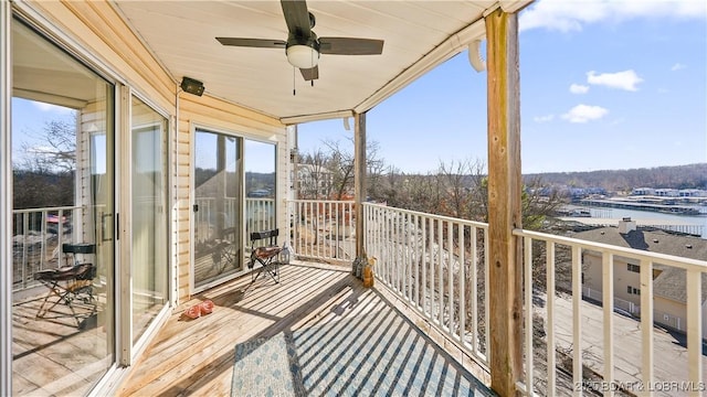 balcony featuring a water view and ceiling fan