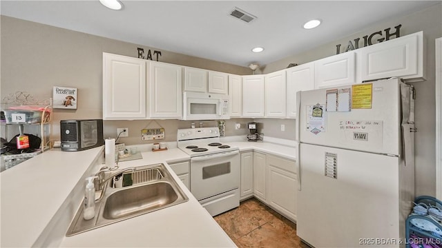 kitchen featuring sink, white appliances, and white cabinets