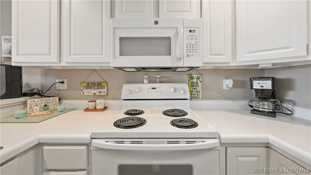 kitchen with white cabinetry and white appliances