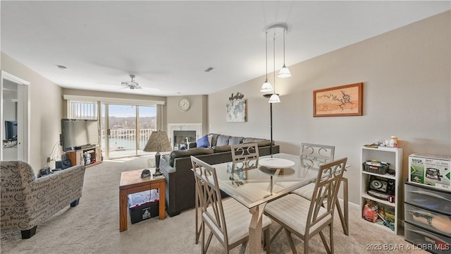 carpeted dining room with ceiling fan