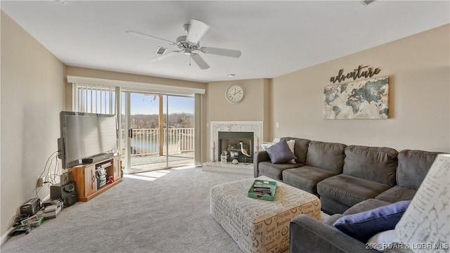 living room with ceiling fan, carpet floors, and a fireplace