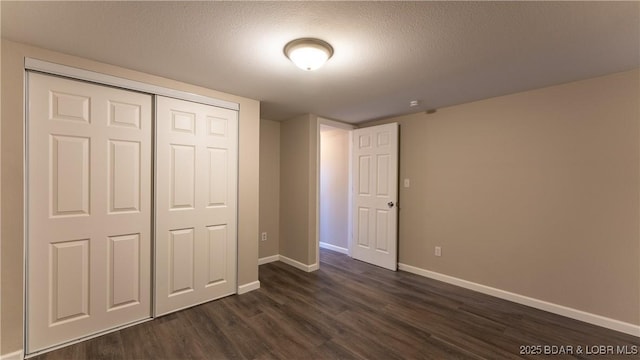 27436 Eola Ln, Rocky Mount, MO 65072 - unfurnished bedroom featuring dark wood-type flooring, a closet, and a textured ceiling
