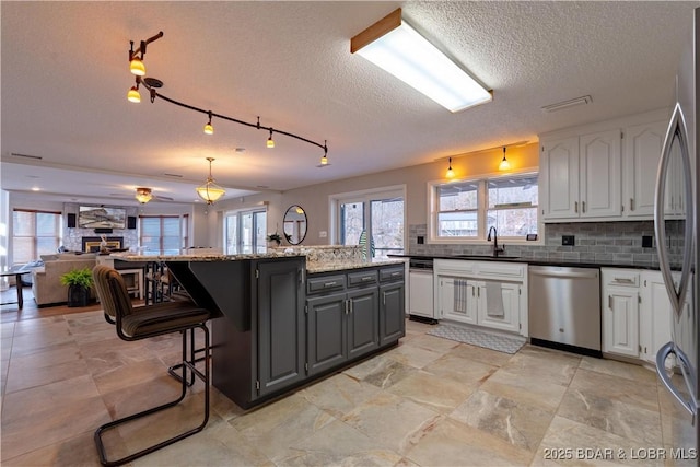 kitchen with sink, gray cabinets, appliances with stainless steel finishes, tasteful backsplash, and white cabinets