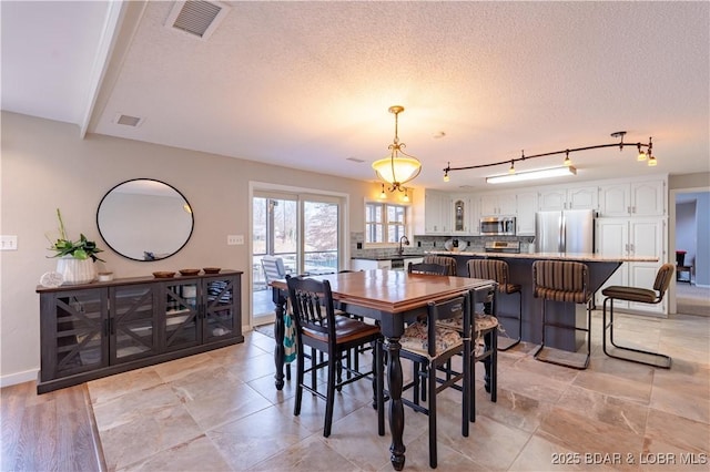 dining area featuring sink and a textured ceiling