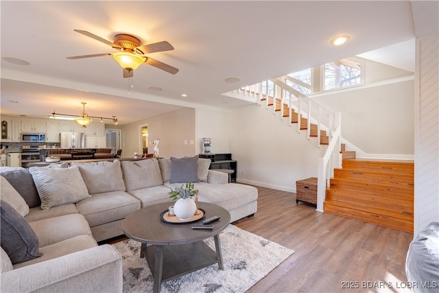 living room featuring ceiling fan and light hardwood / wood-style flooring