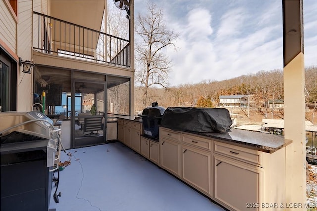 view of patio featuring a balcony, an outdoor kitchen, and a grill