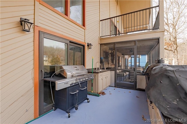 view of patio featuring a balcony, sink, exterior kitchen, and area for grilling