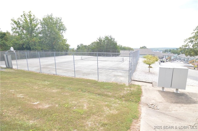 view of tennis court with a yard