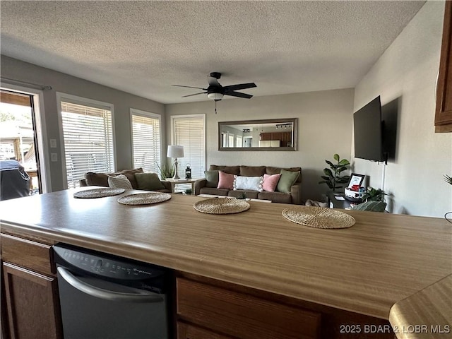 dining area featuring ceiling fan and a textured ceiling