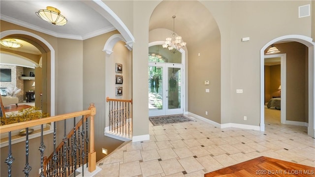 entrance foyer with crown molding and a chandelier