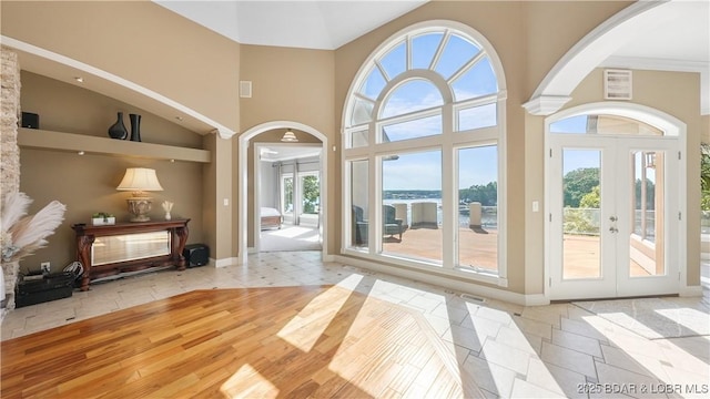 entryway featuring light tile patterned flooring, plenty of natural light, and a high ceiling