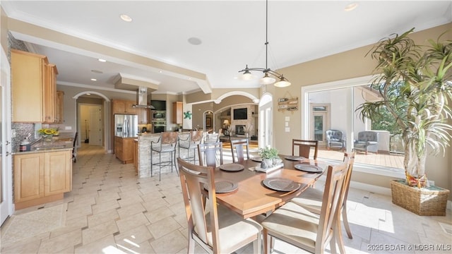 dining room with beam ceiling and ornamental molding