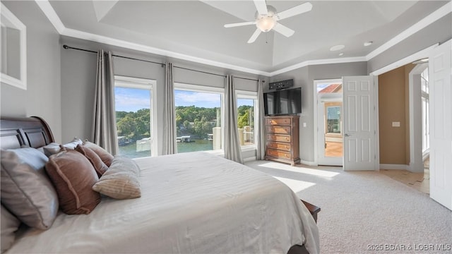 carpeted bedroom with a raised ceiling, access to outside, and ceiling fan