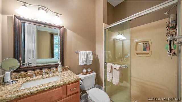 bathroom with toilet, vanity, and walk in shower