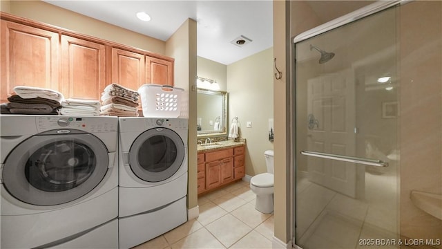 clothes washing area with sink, washer and dryer, and light tile patterned flooring