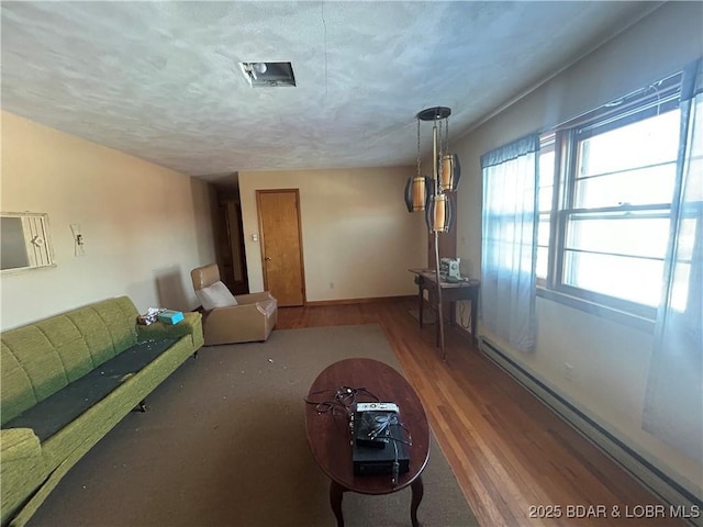 unfurnished living room with baseboard heating, hardwood / wood-style floors, and a textured ceiling