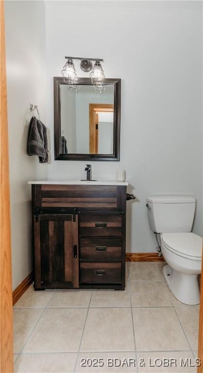 bathroom with tile patterned flooring, vanity, and toilet