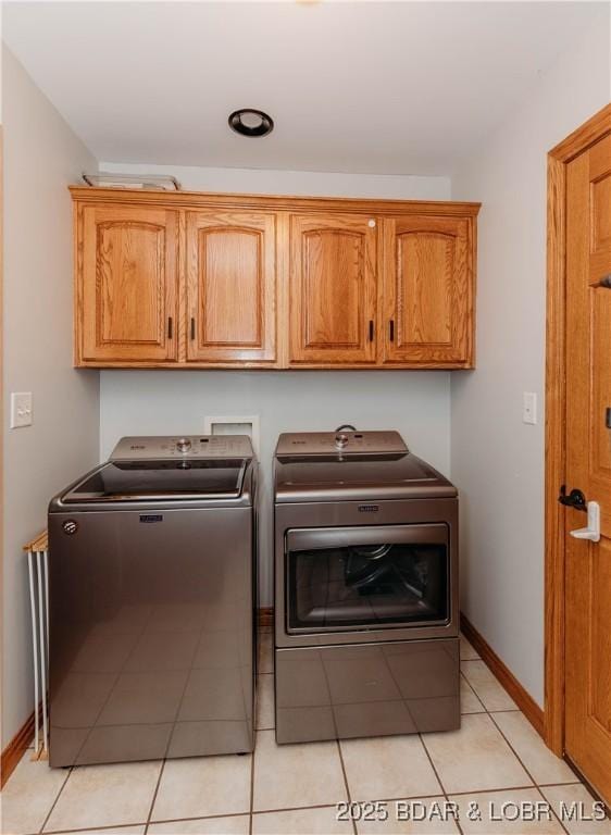 washroom featuring cabinets and washing machine and clothes dryer