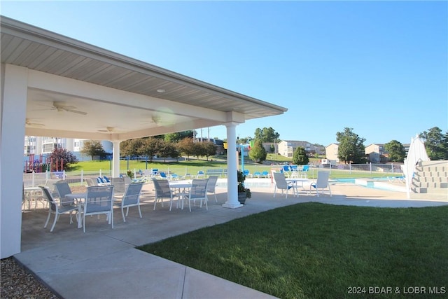 view of yard featuring ceiling fan, a community pool, and a patio area