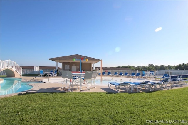 view of swimming pool featuring a patio and a yard