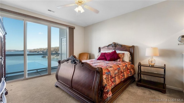 carpeted bedroom featuring a water view, access to outside, and ceiling fan