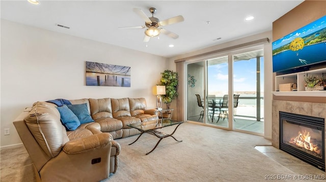 carpeted living room featuring ceiling fan and a fireplace