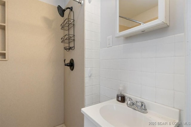 bathroom with tiled shower, sink, and tile walls