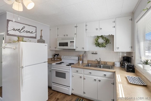 kitchen with white cabinetry, sink, decorative backsplash, dark wood-type flooring, and white appliances