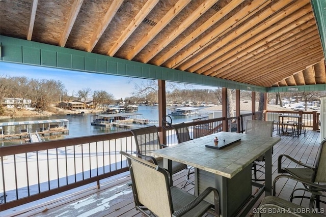 deck featuring exterior bar and a water view