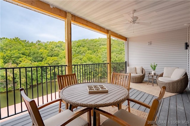 sunroom / solarium with a water view and ceiling fan