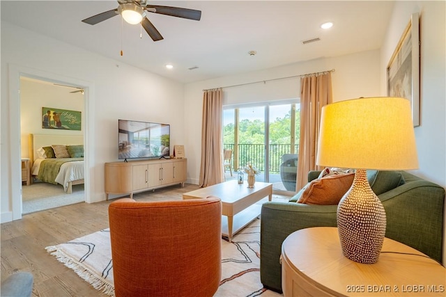 living room featuring ceiling fan and light hardwood / wood-style floors