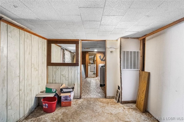 hall featuring wooden walls and concrete floors