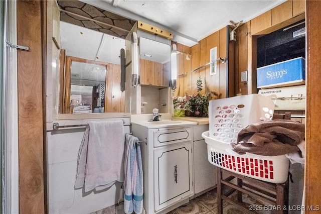 bathroom featuring vanity and wood walls