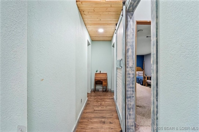 corridor with hardwood / wood-style floors and wood ceiling