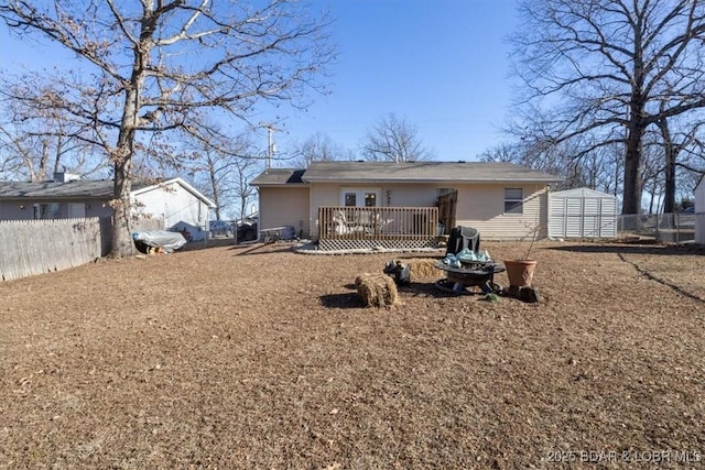 rear view of house featuring a deck and a storage unit